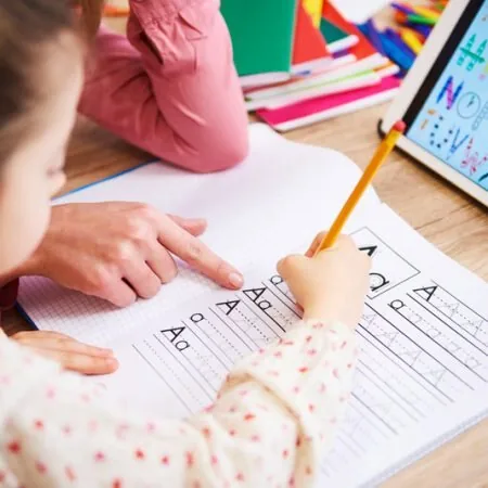 Primer plano de un niño practicando lectoescritura con apoyo psicopedagógico
