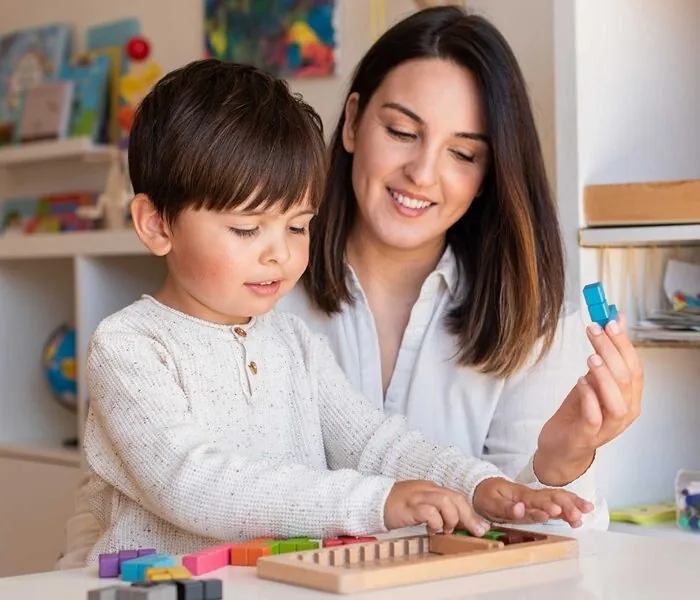 Psicopedagoga acompañando a un niño con material de aprendizaje en casa